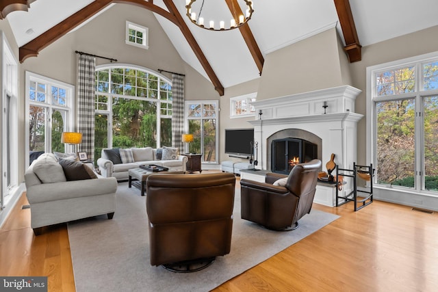 living room featuring beamed ceiling, a chandelier, high vaulted ceiling, and light hardwood / wood-style flooring