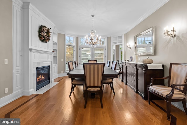 dining room featuring crown molding, a notable chandelier, and light hardwood / wood-style flooring