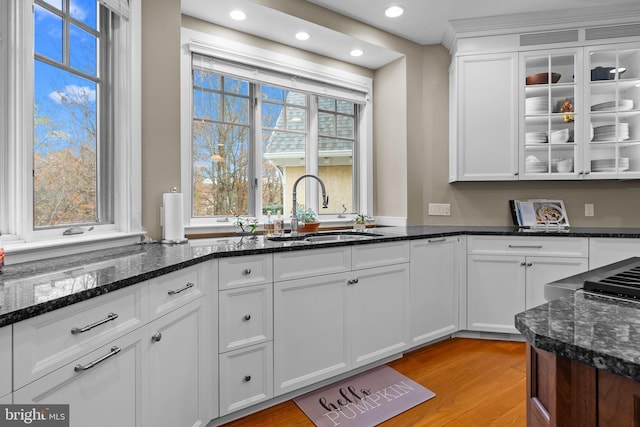 kitchen featuring white cabinetry, sink, and dark stone countertops