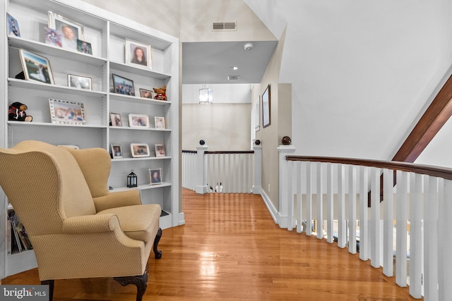 living area with built in features and light hardwood / wood-style floors