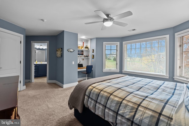 bedroom featuring light carpet, built in desk, and ceiling fan