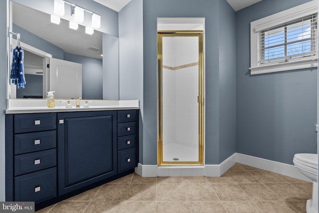 bathroom with vanity, tile patterned floors, a shower with door, and toilet