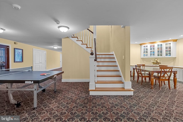 recreation room with dark colored carpet