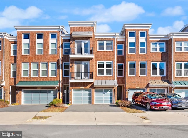 multi unit property featuring a garage, brick siding, and driveway