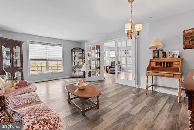 living room featuring french doors, wood-type flooring, and a notable chandelier