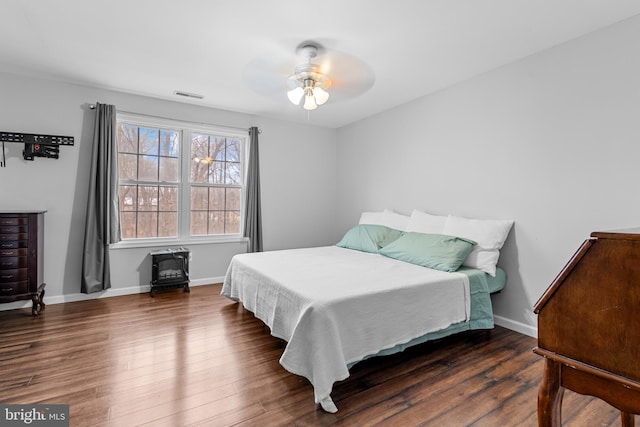 bedroom with dark hardwood / wood-style floors and ceiling fan