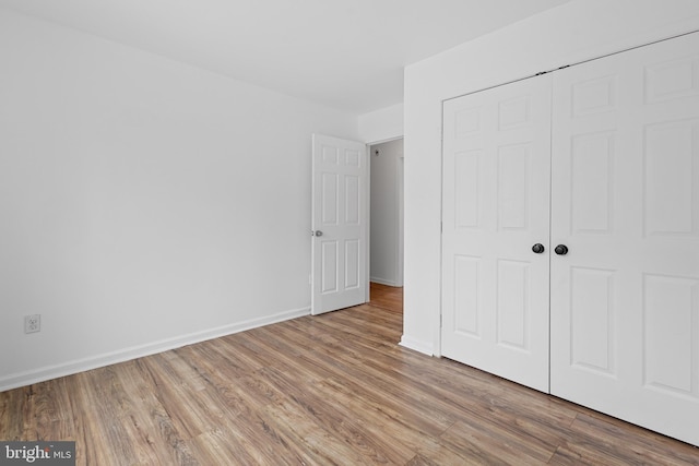 unfurnished bedroom featuring hardwood / wood-style floors and a closet