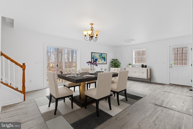 dining area featuring hardwood / wood-style floors and an inviting chandelier