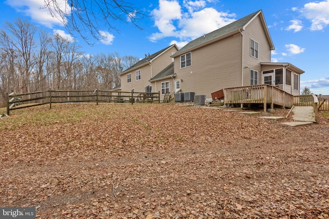 rear view of house featuring central AC, a deck, and a sunroom