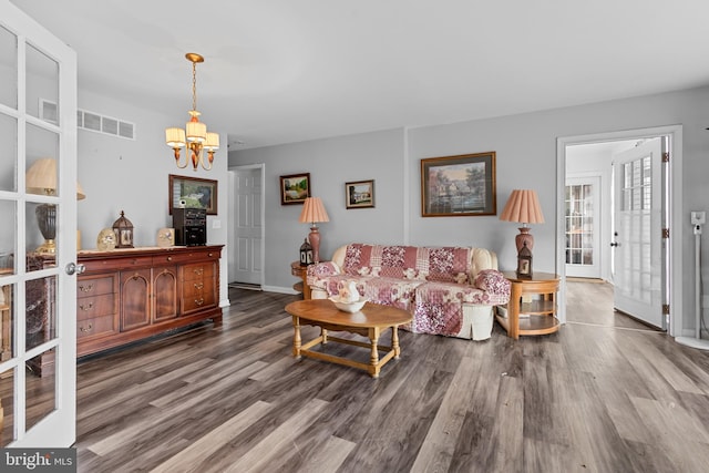 living room featuring hardwood / wood-style floors, french doors, and a notable chandelier