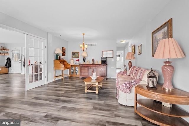 living room with dark hardwood / wood-style floors and a chandelier