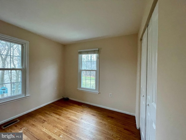 unfurnished room with hardwood / wood-style flooring and plenty of natural light