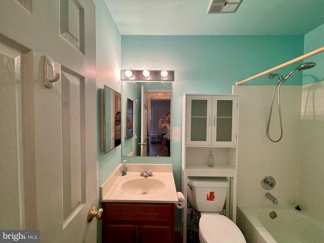 full bathroom with vanity, tiled shower / bath combo, and toilet