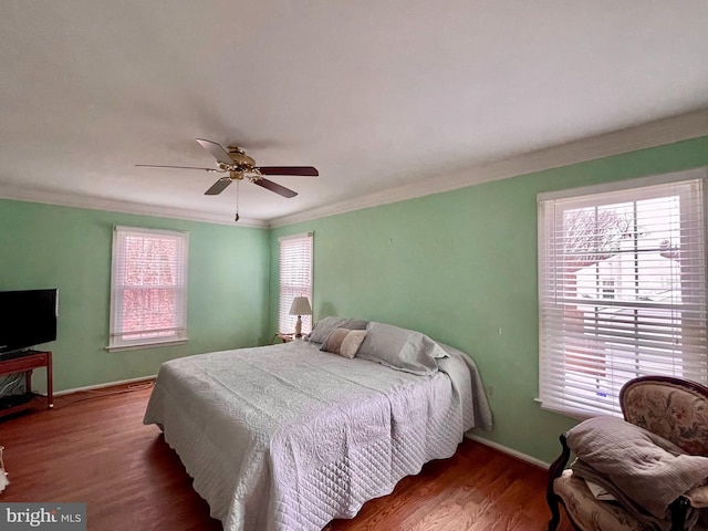 bedroom featuring ceiling fan, dark wood-type flooring, and ornamental molding