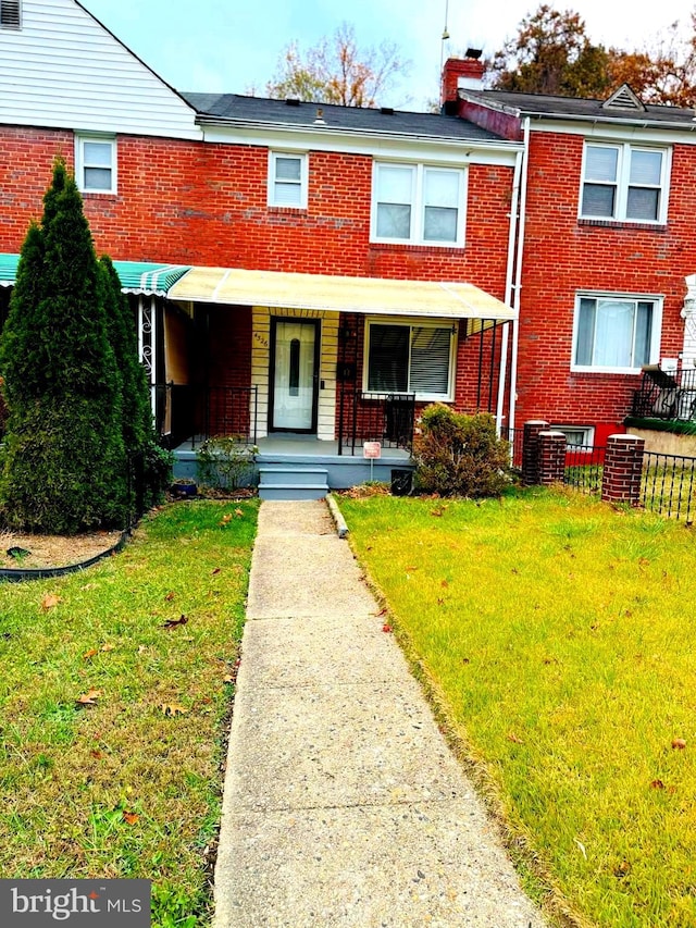 multi unit property featuring a porch and a front yard