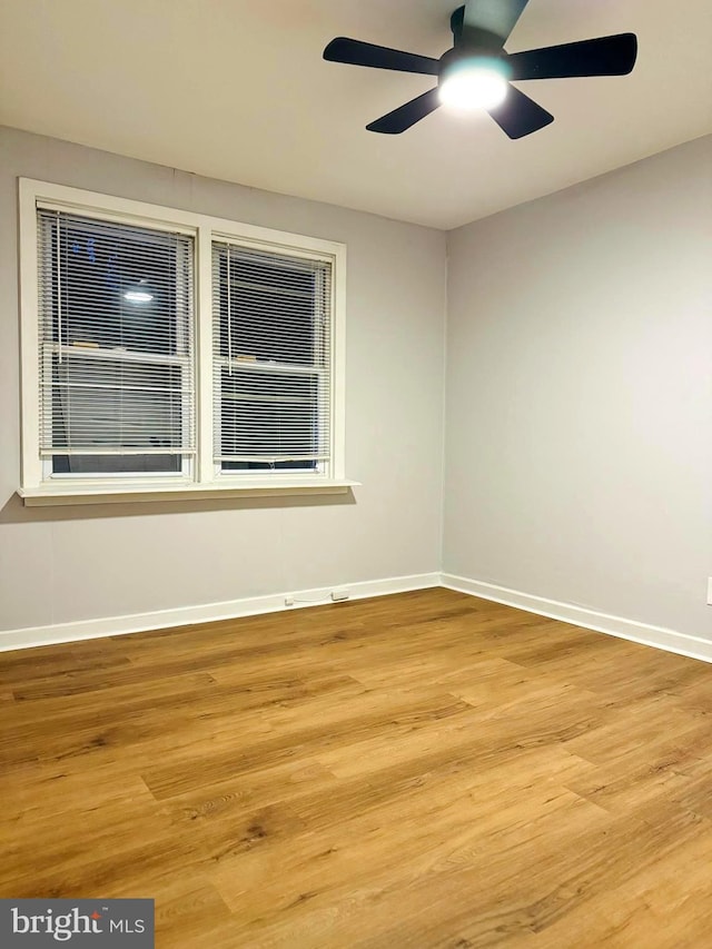 empty room with ceiling fan and light hardwood / wood-style flooring