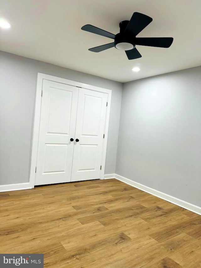 unfurnished bedroom featuring light wood-type flooring, a closet, and ceiling fan