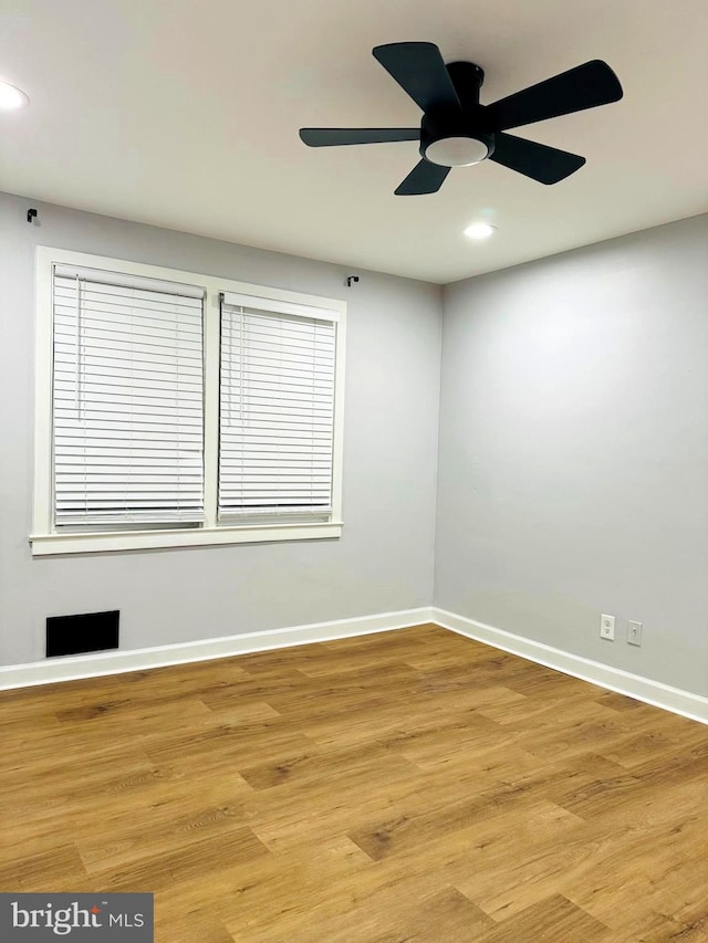 spare room with light wood-type flooring and ceiling fan