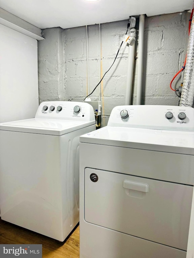 laundry area with hardwood / wood-style floors and washer and dryer