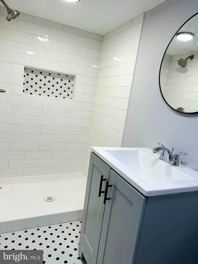 bathroom featuring a tile shower, tile patterned floors, and vanity