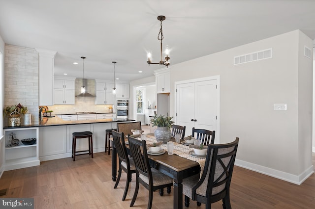 dining area with recessed lighting, visible vents, a chandelier, light wood-type flooring, and baseboards