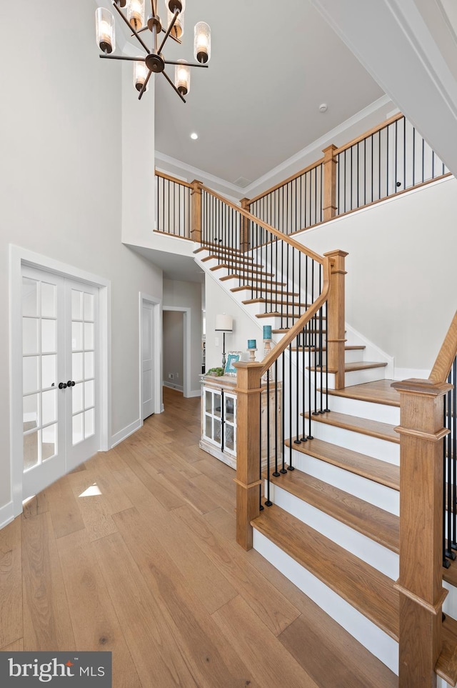 stairway featuring ornamental molding, french doors, hardwood / wood-style flooring, and baseboards