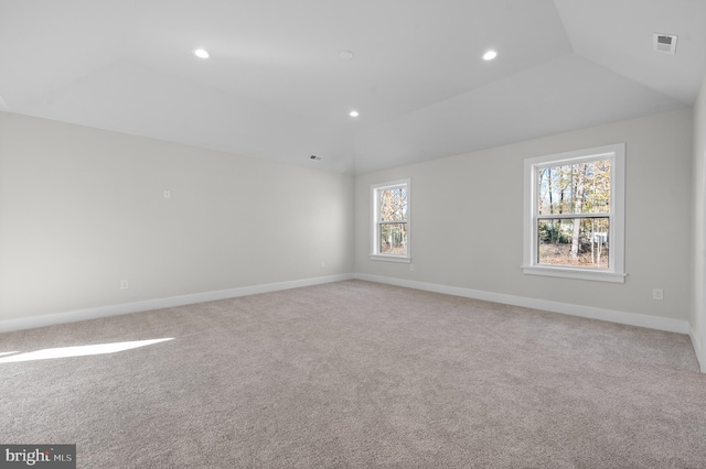 empty room with recessed lighting, light colored carpet, visible vents, vaulted ceiling, and baseboards