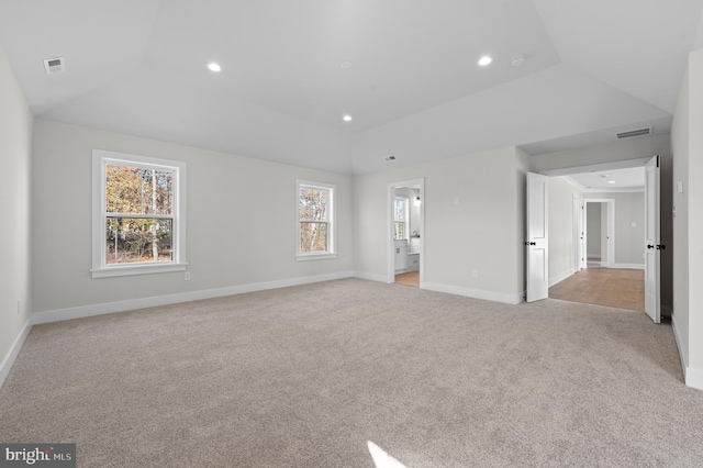 unfurnished bedroom with lofted ceiling, visible vents, light carpet, and recessed lighting