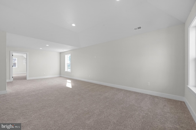 unfurnished room featuring recessed lighting, visible vents, light carpet, vaulted ceiling, and baseboards