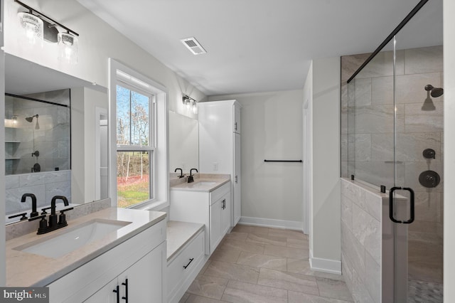 full bathroom featuring two vanities, visible vents, a sink, and a shower stall