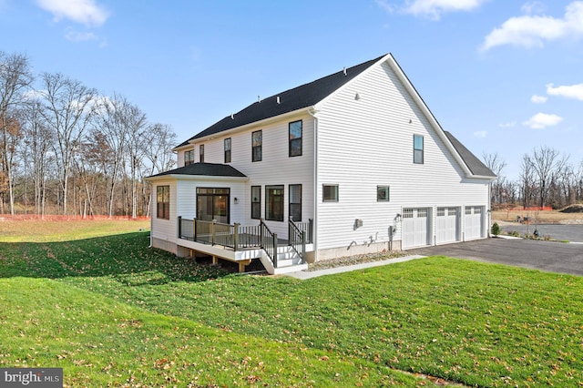 back of property with a garage, aphalt driveway, and a yard