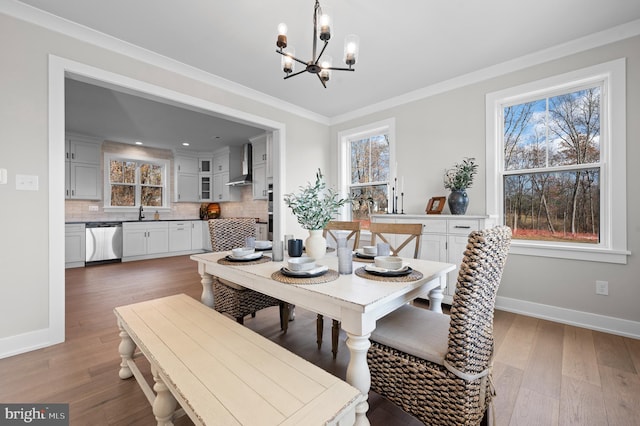 dining space featuring plenty of natural light, ornamental molding, a chandelier, and wood finished floors