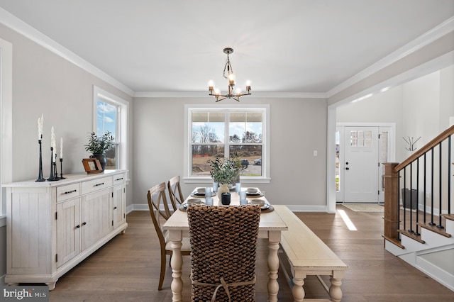 dining room with ornamental molding, wood finished floors, an inviting chandelier, and stairs