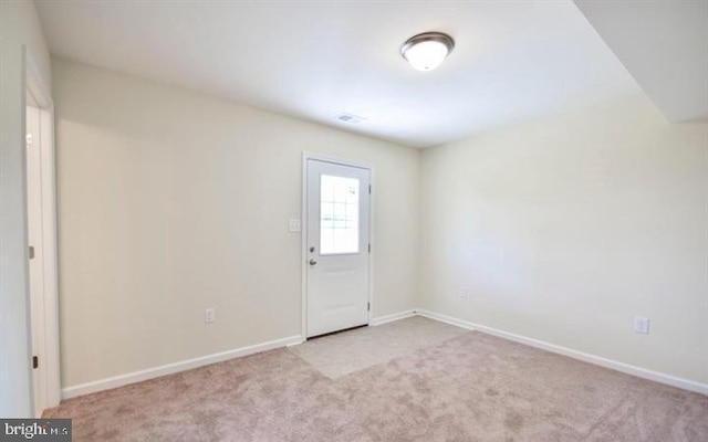 spare room featuring light carpet