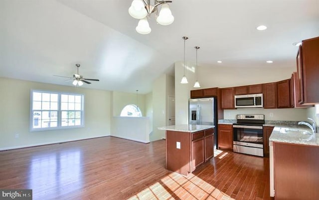 kitchen featuring a center island, dark hardwood / wood-style flooring, stainless steel appliances, and vaulted ceiling