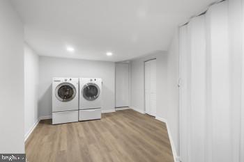 laundry area featuring washer and dryer and light hardwood / wood-style floors