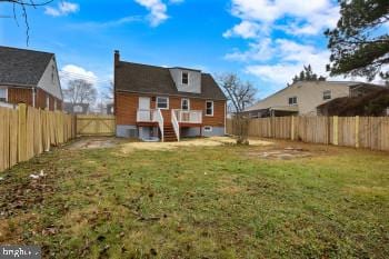 rear view of property featuring a lawn