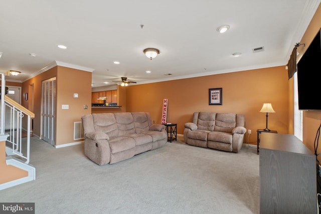 carpeted living room featuring ceiling fan and ornamental molding