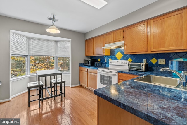 kitchen with backsplash, sink, white electric stove, light hardwood / wood-style floors, and hanging light fixtures