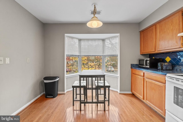 kitchen with decorative backsplash, light hardwood / wood-style flooring, pendant lighting, and white electric stove