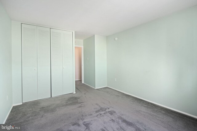 unfurnished bedroom with carpet and a closet