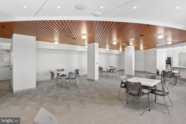 dining area with wood ceiling and light carpet