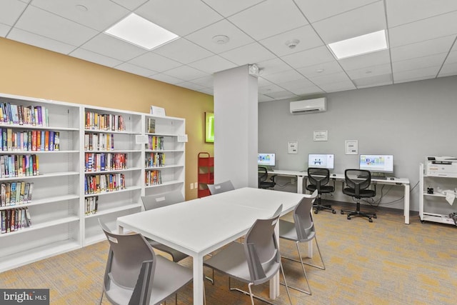 office area featuring a paneled ceiling, an AC wall unit, and carpet floors