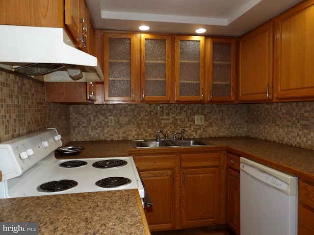 kitchen featuring a tray ceiling, tasteful backsplash, sink, and white appliances