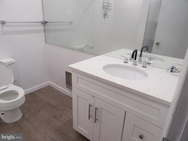 bathroom with a shower, hardwood / wood-style floors, vanity, and toilet