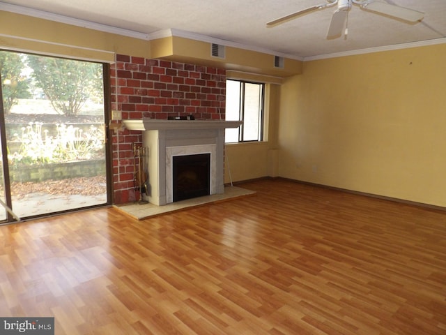 unfurnished living room with hardwood / wood-style floors, ceiling fan, a premium fireplace, and ornamental molding