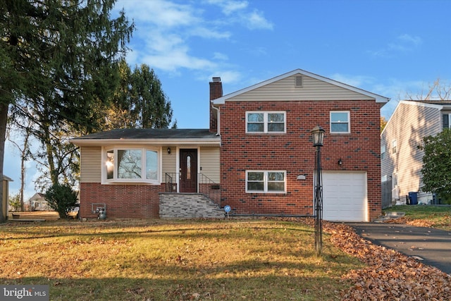 split level home with a front lawn and a garage