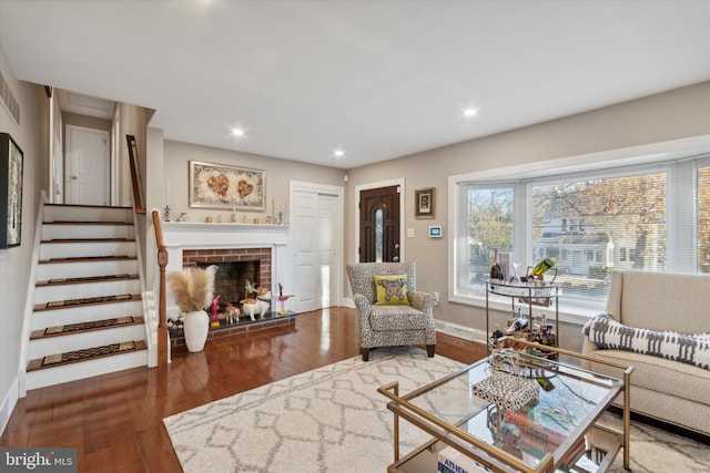 living room featuring hardwood / wood-style floors and a brick fireplace