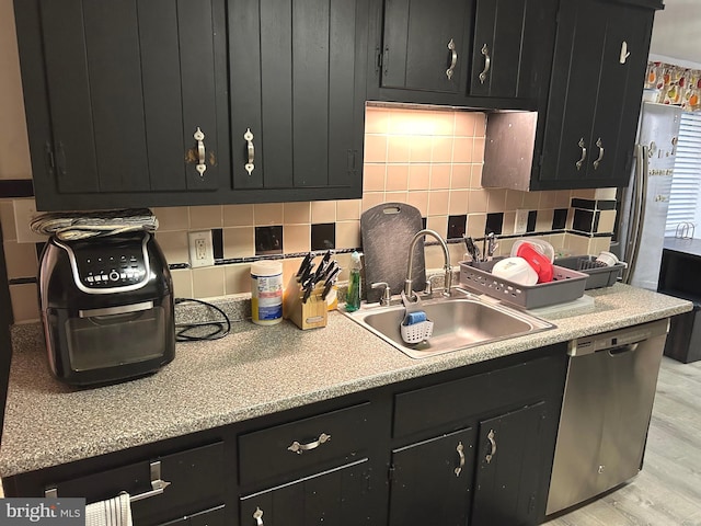 kitchen with backsplash, sink, dishwasher, and light wood-type flooring