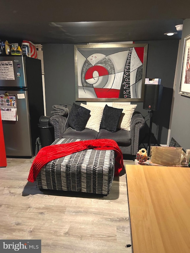 bedroom featuring stainless steel refrigerator and hardwood / wood-style flooring